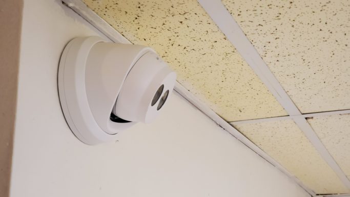 Ceiling-mounted security camera with a white casing.